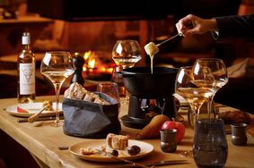 Freunde geniessen ein leckeres Fondue im Chalet Max. 